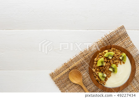 Top view of yogurt in a wooden bowl and mint Top view of yogurt in a wooden bowl and mint 49227434