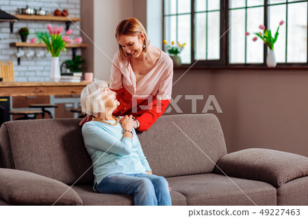 Graceful elderly mom with grey hair lovingly holding daughter palm 49227463
