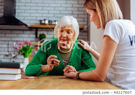 Young-adult woman comforting religious blue grey-haired woman in years 49227607