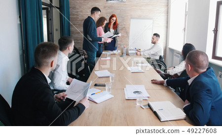 A business conference. People checking the report 49227608
