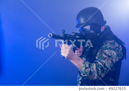 Soldier holding assault rifle in smoky haze Soldier holding assault rifle in smoky haze 49227635