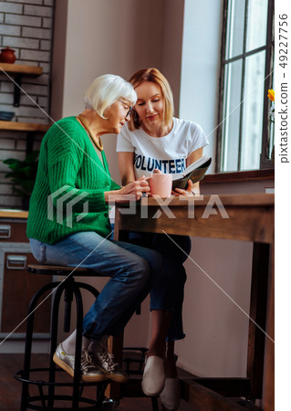 Two sitting beautiful women of different generation and reading Bible 49227756