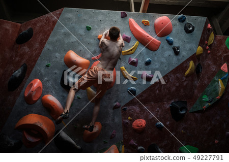 Athletic man practicing in a bouldering gym 49227791