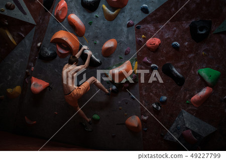 Athletic man practicing in a bouldering gym 49227799