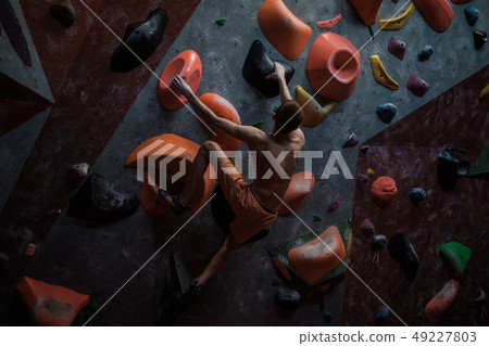 Athletic man practicing in a bouldering gym 49227803