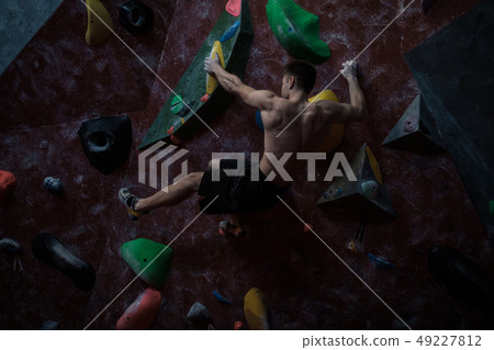 Athletic man practicing in a bouldering gym 49227812