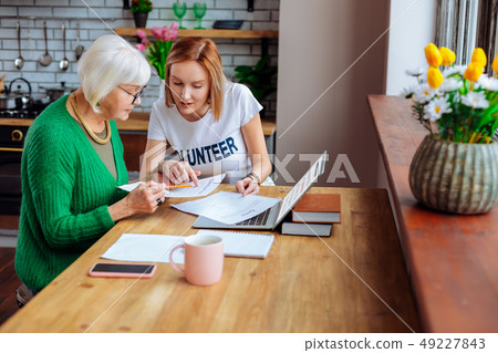 Welfare department worker pointing out at loan items to woman Welfare department worker pointing out at loan items to woman 49227843