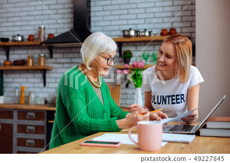 Dame asking questions about docs while blond woman clarifying them