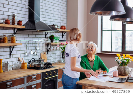Nice female explaining elderly dame items of overdue loan notification 49227869