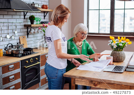Young woman clarifying elderly madam items of overdue loan notification 49227873