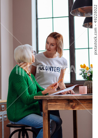 Charming lady having discussion with young-adult girl about documents 49228022
