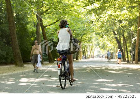 Girl biking & calling in the Amsterdam Vondelpark. 49228523