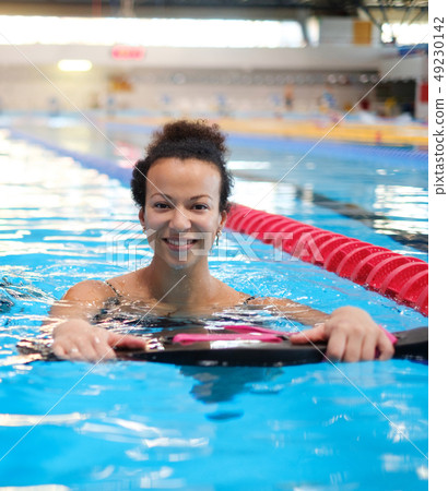Black woman attending water aerobics class in a swimming pool Black woman attending water aerobics class in a swimming pool 49230142