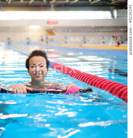 Black woman attending water aerobics class in a swimming pool 49230145