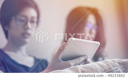 Two Asian friends watching thing on tablet and Two Asian friends watching thing on tablet and 49231602
