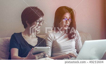 Two Asian friends watching thing on tablet and 49231604