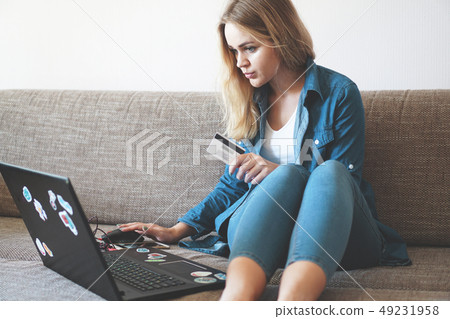 Young pretty woman working with laptop and credit card at home Young pretty woman working with laptop and credit card at home 49231958