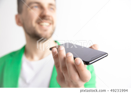 Indoor portrait of attractive young man holding smartphone Indoor portrait of attractive young man holding smartphone 49231994