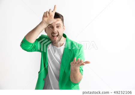 Losers go home. Portrait of happy guy showing loser sign over forehead Losers go home. Portrait of happy guy showing loser sign over forehead 49232106