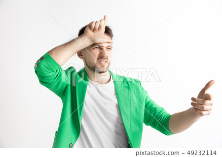 Losers go home. Portrait of happy guy showing loser sign over forehead Losers go home. Portrait of happy guy showing loser sign over forehead 49232114