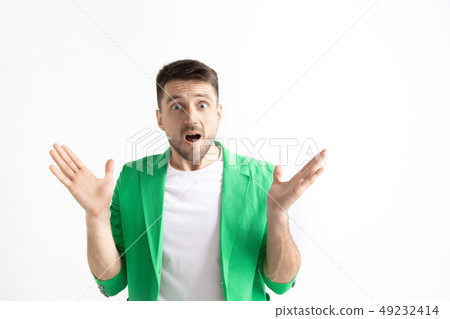 The young attractive man looking suprised isolated on gray The young attractive man looking suprised isolated on gray 49232414