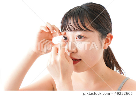 Woman doing contact lens Woman doing contact lens 49232665
