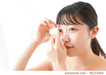 Woman doing contact lens Woman doing contact lens 49232668