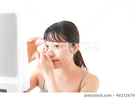 Woman doing contact lens Woman doing contact lens 49232679