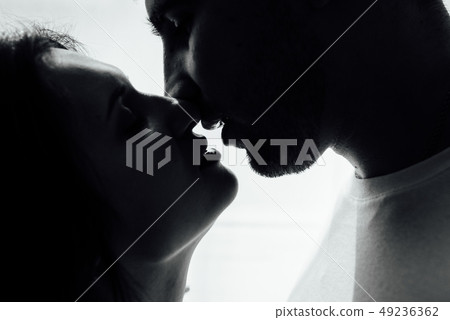 Couple kissing near window. Man and woman in darkness. Sweet taste of your lips 49236362