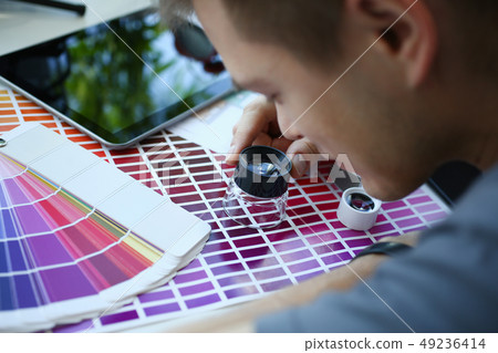 Male serviceman hold in hand magnifying glass making colour test Male serviceman hold in hand magnifying glass making colour test 49236414