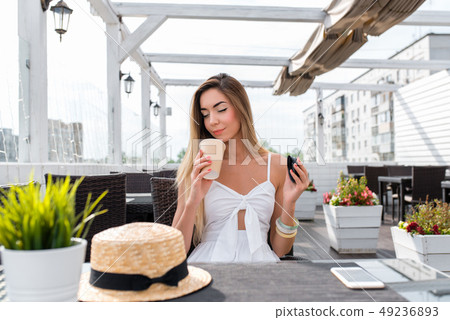 The girl in the cafe. Sniffs and enjoys coffee, inhales the aroma gets pleasure from the smell of The girl in the cafe. Sniffs and enjoys coffee, inhales the aroma gets pleasure from the smell of 49236893