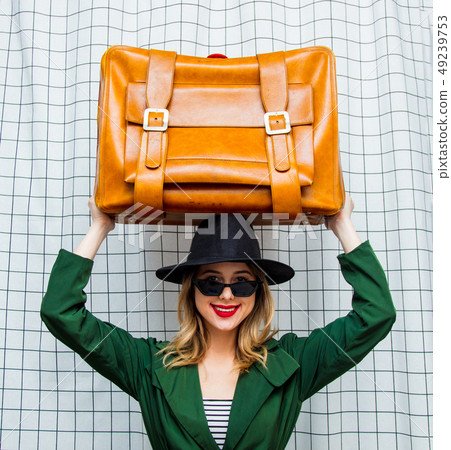 woman in hat and green cloak in 90s style with travel suitcase woman in hat and green cloak in 90s style with travel suitcase 49239753