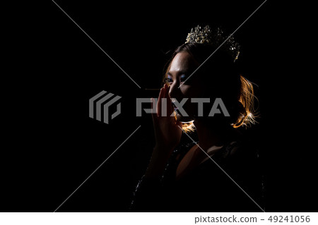 Portrait Silhouette Shadow Back Rim Light of Miss Pageant Beauty Queen Contest Silver Diamond Crown wave hand express feeling smile, studio lighting dark black background, turn back head to camera Portrait Silhouette Shadow Back Rim Light of Miss Pageant Beauty Queen Contest Silver Diamond Crown wave hand express feeling smile, studio lighting dark black background, turn back head to camera 49241056