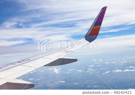 Aircraft Wing on blue sky and white clouds Aircraft Wing on blue sky and white clouds 49242421