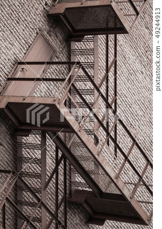 Metal stairway over red brick wall 49244913