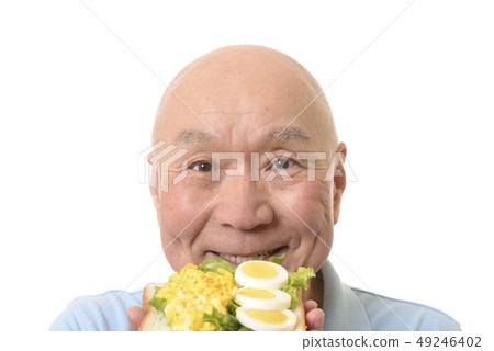 Senior eating egg dish on bread Senior eating egg dish on bread 49246402