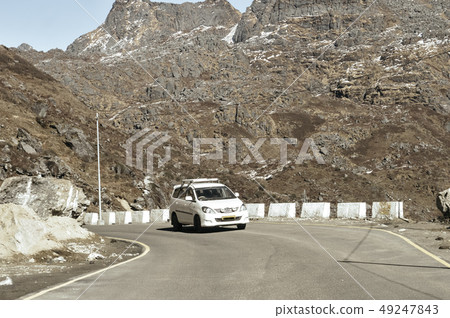 Car traveling downhill on curved mountain roads. 49247843