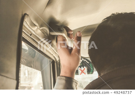 Man Hand on handle sit front passenger of a car 49248737