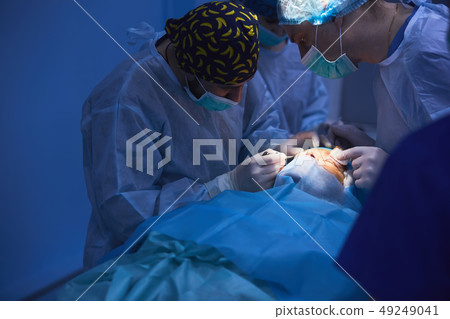 Surgical team performing surgery in modern operation theater,Team of doctors concentrating on a Surgical team performing surgery in modern operation theater,Team of doctors concentrating on a 49249041