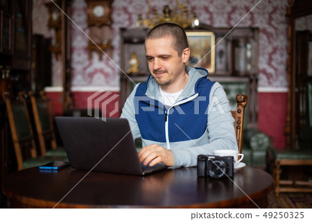 Man freelancer with laptop and camera working 49250325