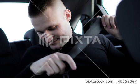 Businessman in his car fastening the seatbelt, safe driving concept Businessman in his car fastening the seatbelt, safe driving concept 49255067