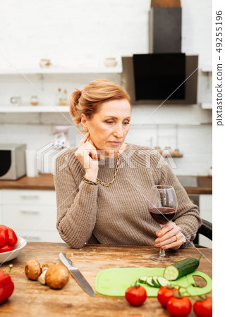 Thoughtful light-haired woman preparing light dinner with vegetables Thoughtful light-haired woman preparing light dinner with vegetables 49255196