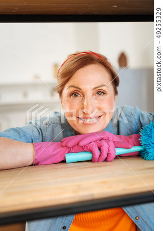 Cheerful light-haired woman with brown eyes being happy while cleaning Cheerful light-haired woman with brown eyes being happy while cleaning 49255329
