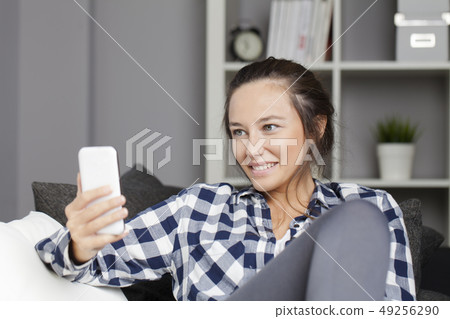 Young woman in sofa with smartphone Young woman in sofa with smartphone 49256290