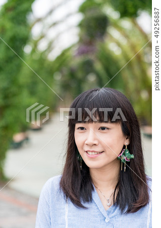 A virgin who is in the park. Park-like stalls and baloons. 49256887