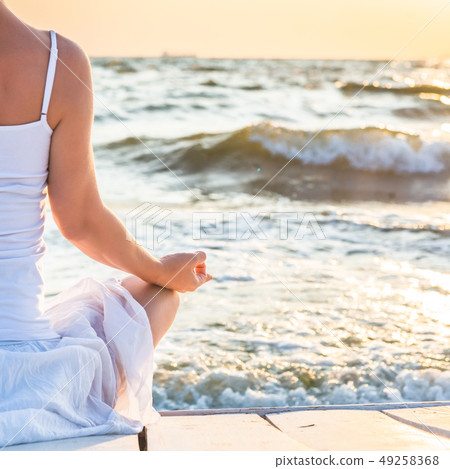 Woman meditating at the sea Woman meditating at the sea 49258368