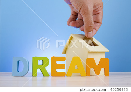 hand putting coins into house piggy bank hand putting coins into house piggy bank 49259553