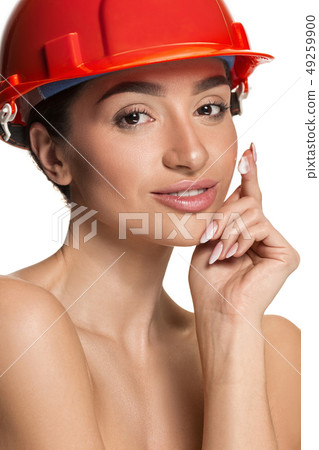 Portrait of confident female worker in orange helmet Portrait of confident female worker in orange helmet 49259900