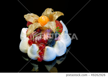 Close up of meringue cake with berries isolated on darkbackground. 49262926