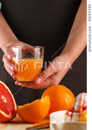 girl holding a glass of fresh citrus juice girl holding a glass of fresh citrus juice 49263394